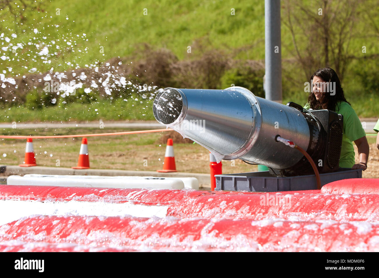 Eine junge Frau, betreibt eine Blase Maschine der Schaum Grube mit Seifenlauge zu füllen, an die lächerliche Hindernis Herausforderung am 5. April 2014 in Atlanta, GA. Stockfoto