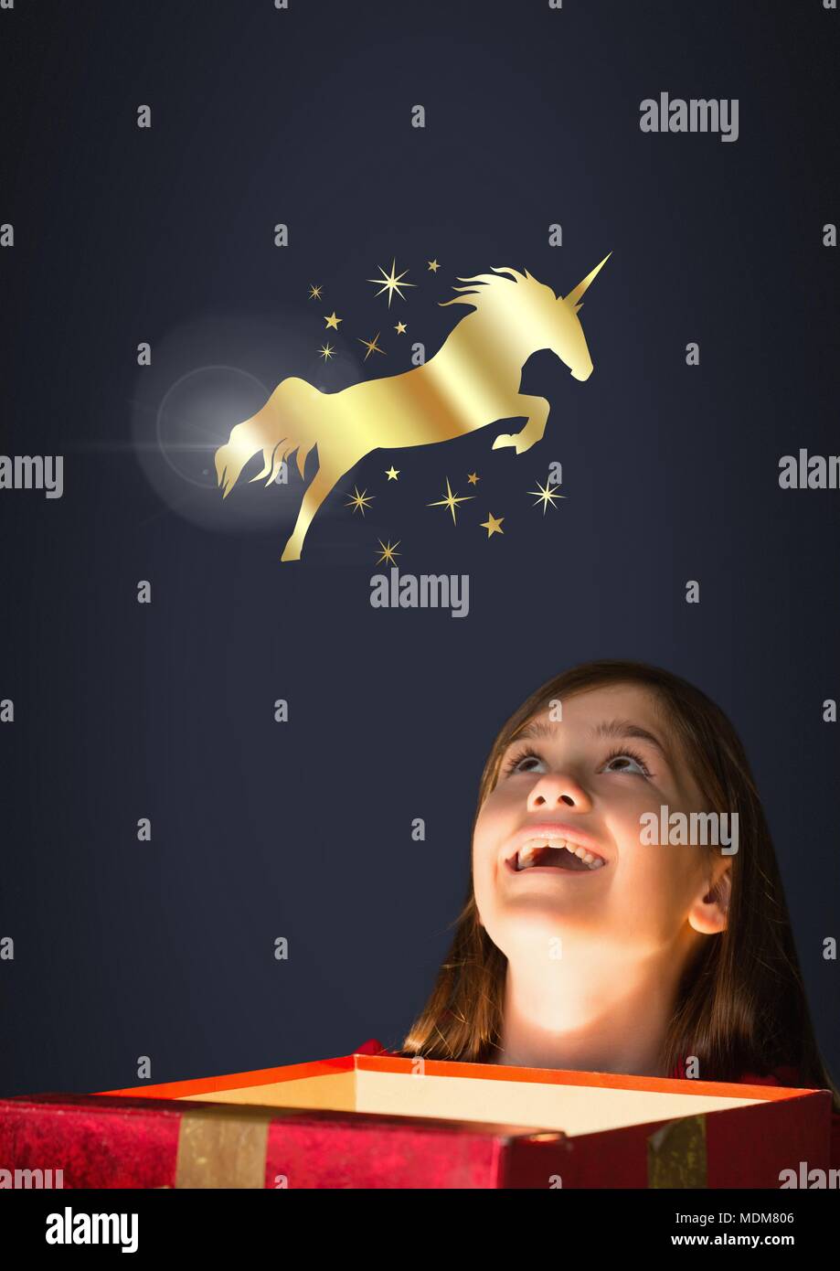 Goldenes Einhorn und Sterne über Magic Light Box und kleine Mädchen Stockfoto