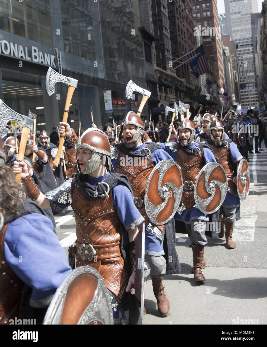 Platoon der Männer mit Schlacht Achsen & Schilde, die die Vikings die schottische Unabhängigkeit feiern im Jahre 1320 bei der jährlichen Tartan Parade in New York City proklamiert. Die Parade marschiert nach Norden auf der 6. Avenue in Midtown Manhattan. Stockfoto