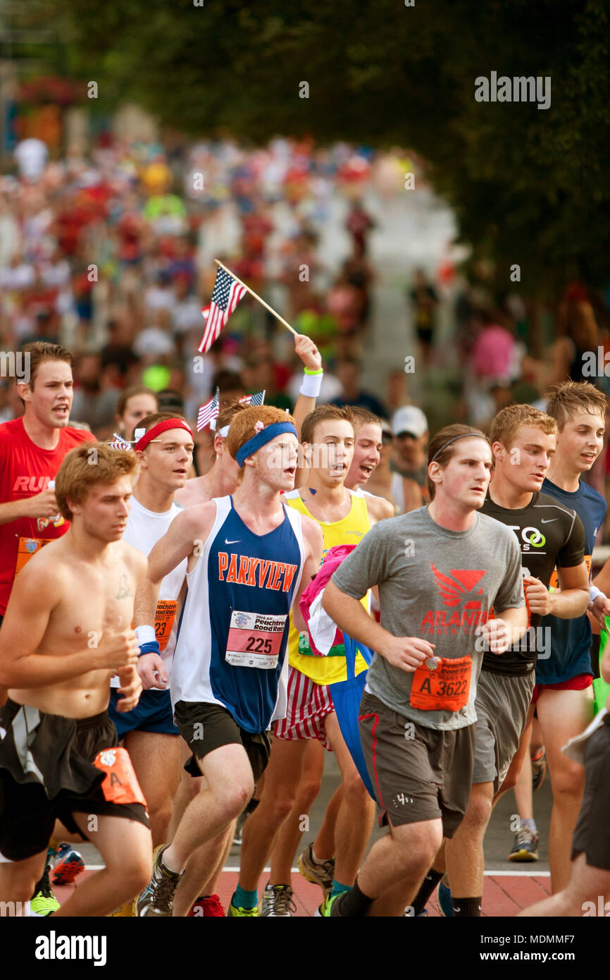 Eine Hand mit einer kleinen amerikanischen Flagge steigt über die Schar der Läufer kurz vor der Ziellinie der Peachtree Road Race am 4. Juli 2014 in Atlanta, GA. Stockfoto
