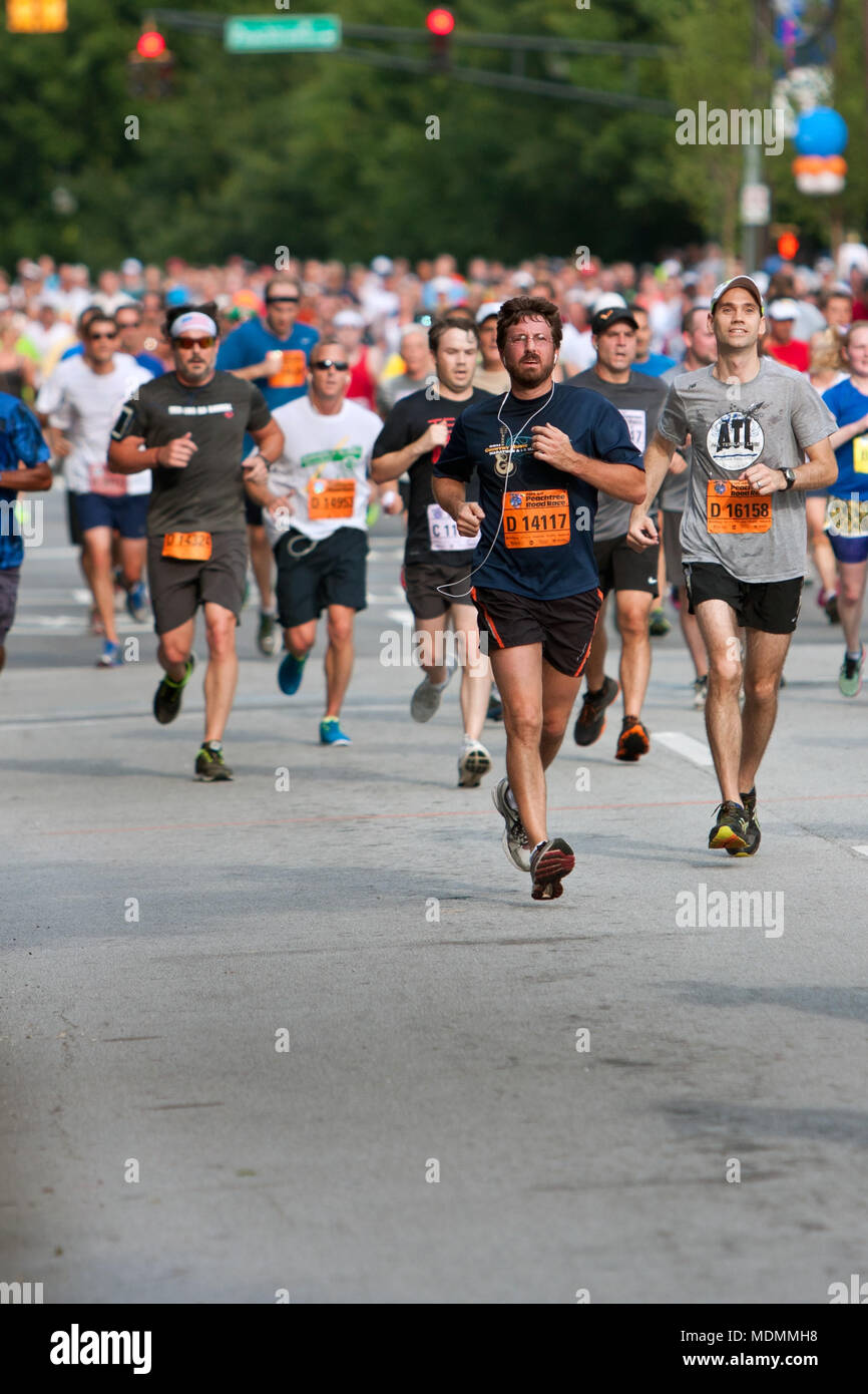 Atlanta, GA, USA - Juli 4, 2014: Tausende von Läufern fließt ein Atlanta Straße auf dem Weg zur Ziellinie der Peachtree Road Race. Stockfoto