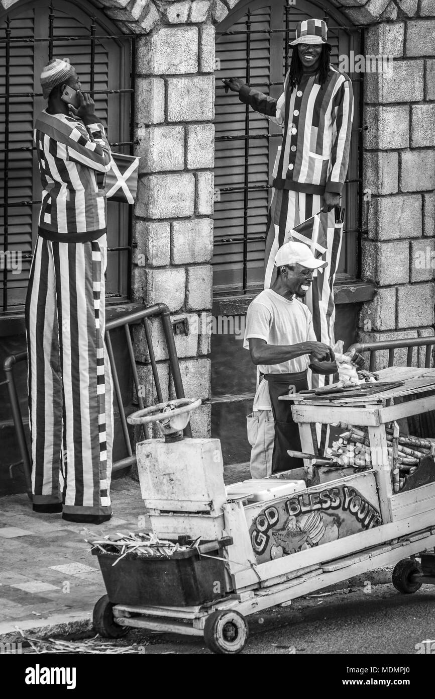 Hohe Maskottchen zu unterhalten, Touristen und eine frische Früchte Anbieter stehen vor Jimmy Buffet's Margaritaville Montego Bay in Jamaika Stockfoto