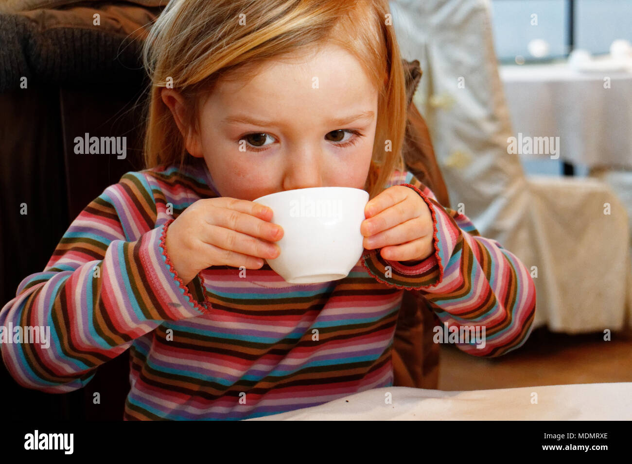 Ein kleines Mädchen (3 Jahre alt) trinken grünen Tee von Teetasse in einem chinesischen Restaurant Stockfoto