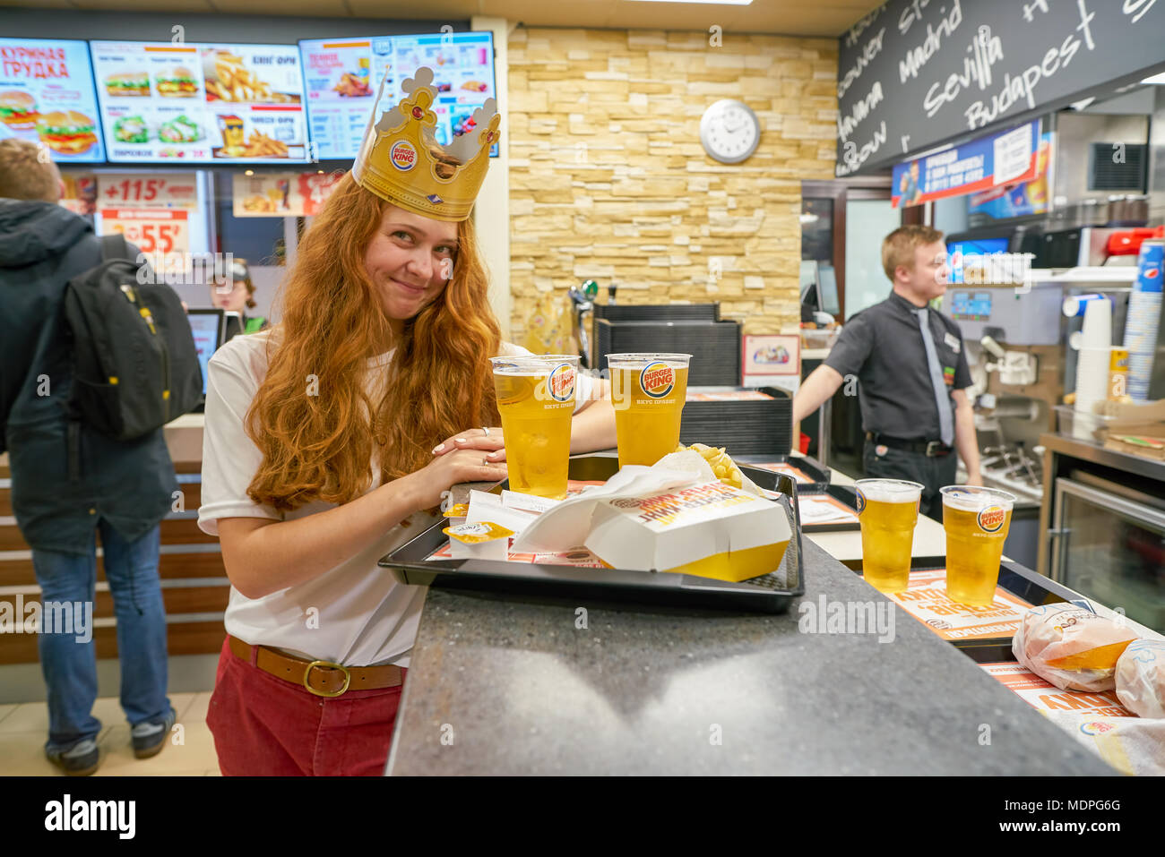 Sankt Petersburg - ca. Oktober 2017: Frau mit einem Karton Krone bei Burger King Restaurant. Burger King ist eine US-amerikanische globale Kette der Hamburger f Stockfoto