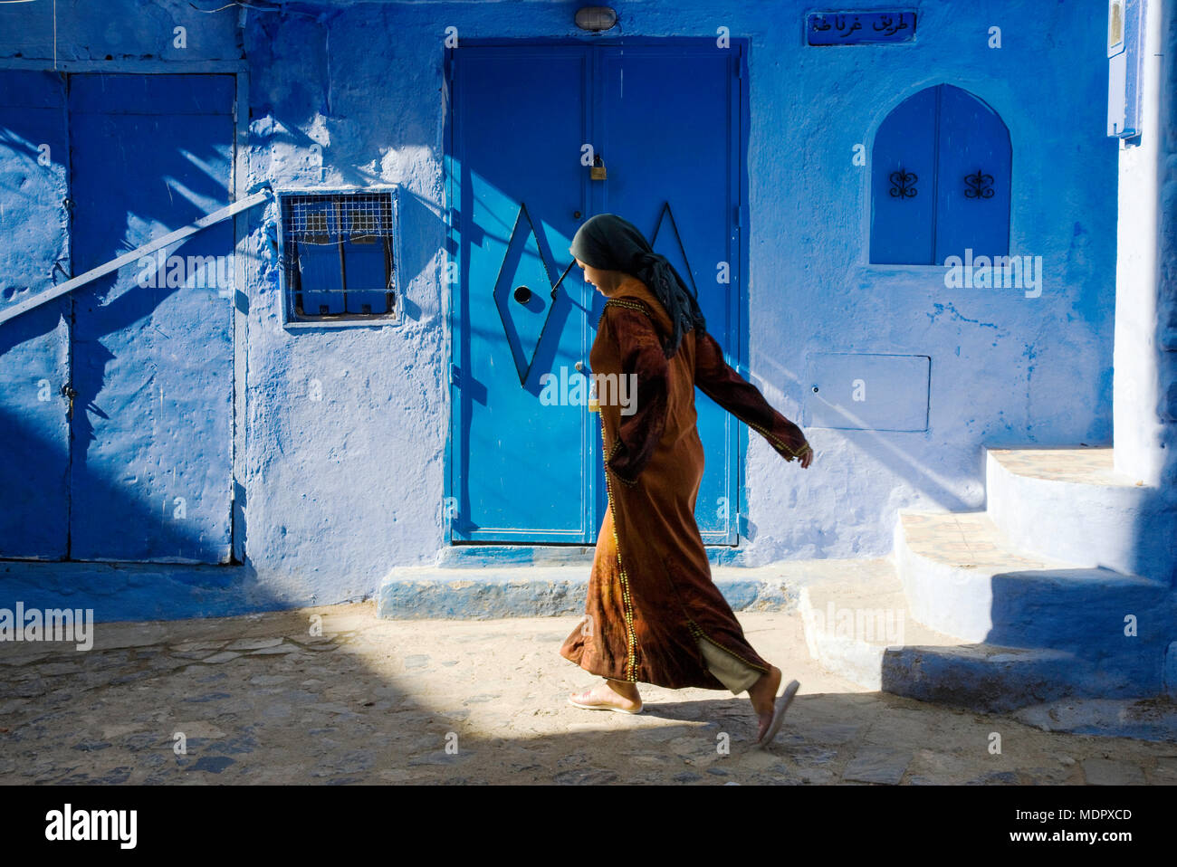 Chefchaouen, Marokko; Frau in traditioneller Kleidung in der Altstadt. Stockfoto