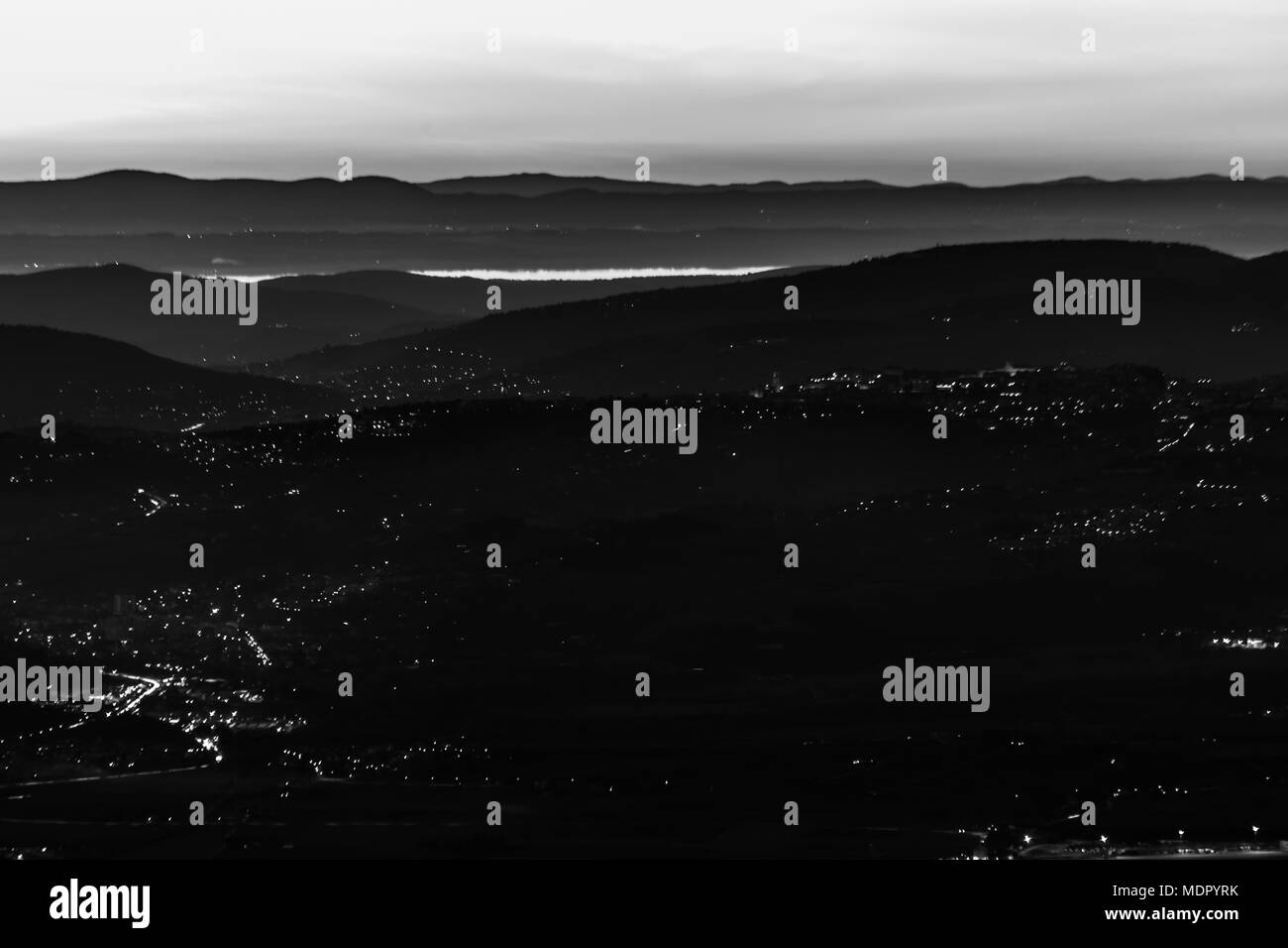 Schöne Luftaufnahme von Umbrien (Italien) Tal in der Dämmerung, mit Hügeln, Perugia city lights und Trasimeno See widerspiegeln Sky Light Stockfoto