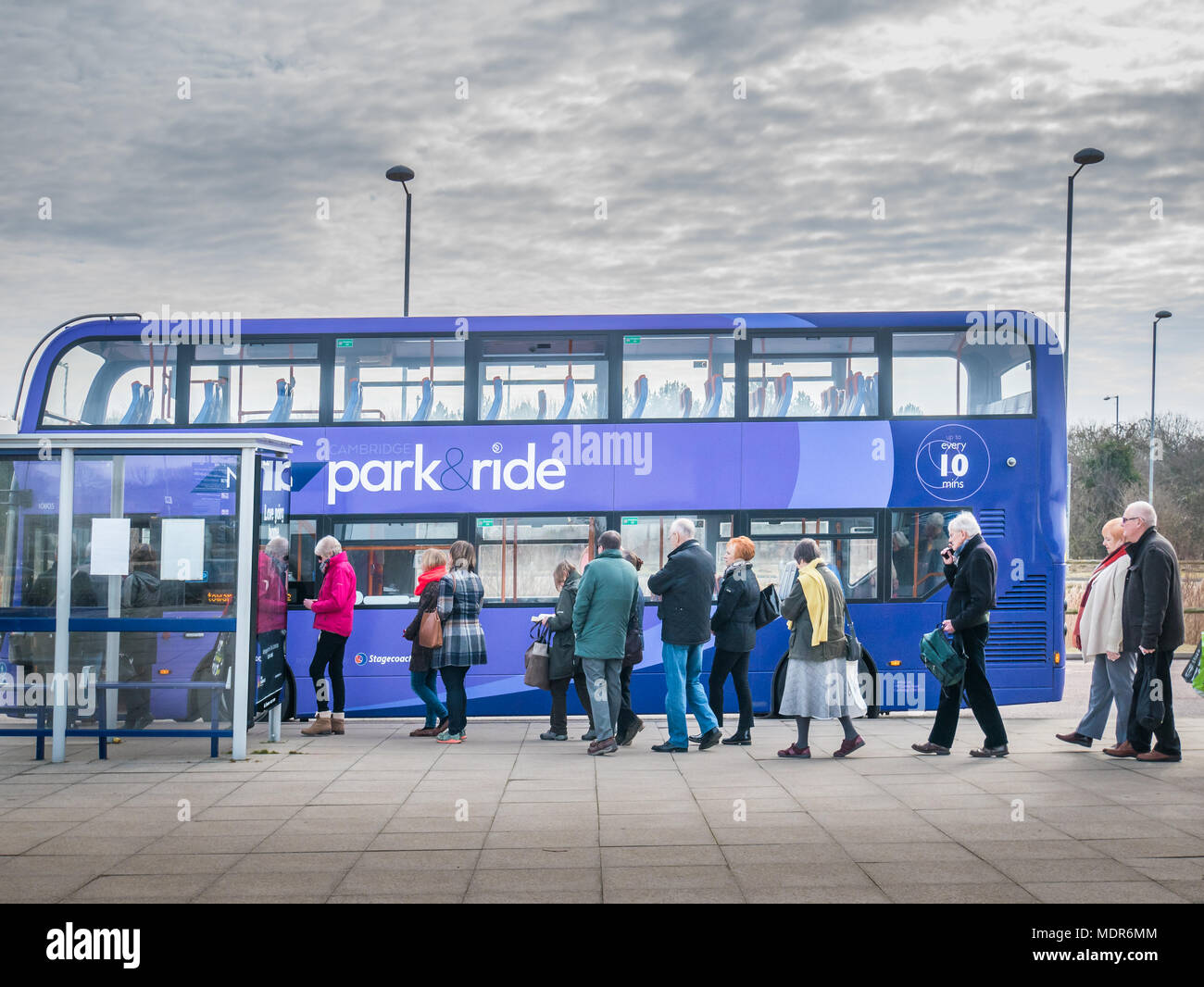 Passagiere Form eine geordnete Warteschlange auf dem Bürgersteig der Cambridge (England) Park&Ride Bus board im Milton Terminal an. Stockfoto Passagiere Form eine geordnete Warteschlange auf dem Bürgersteig der Cambridge (England) Park&Ride Bus board im Milton Terminal an. Stockfoto