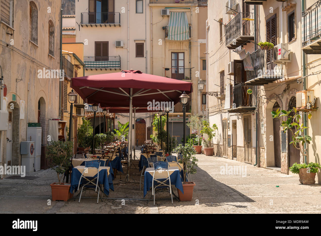 Tisch und Stühle draußen ein Restaurant, L'Antica Corte, in Cefalu, Sizilien, Italien auf einem sonnigen Sommertag im August. Stockfoto