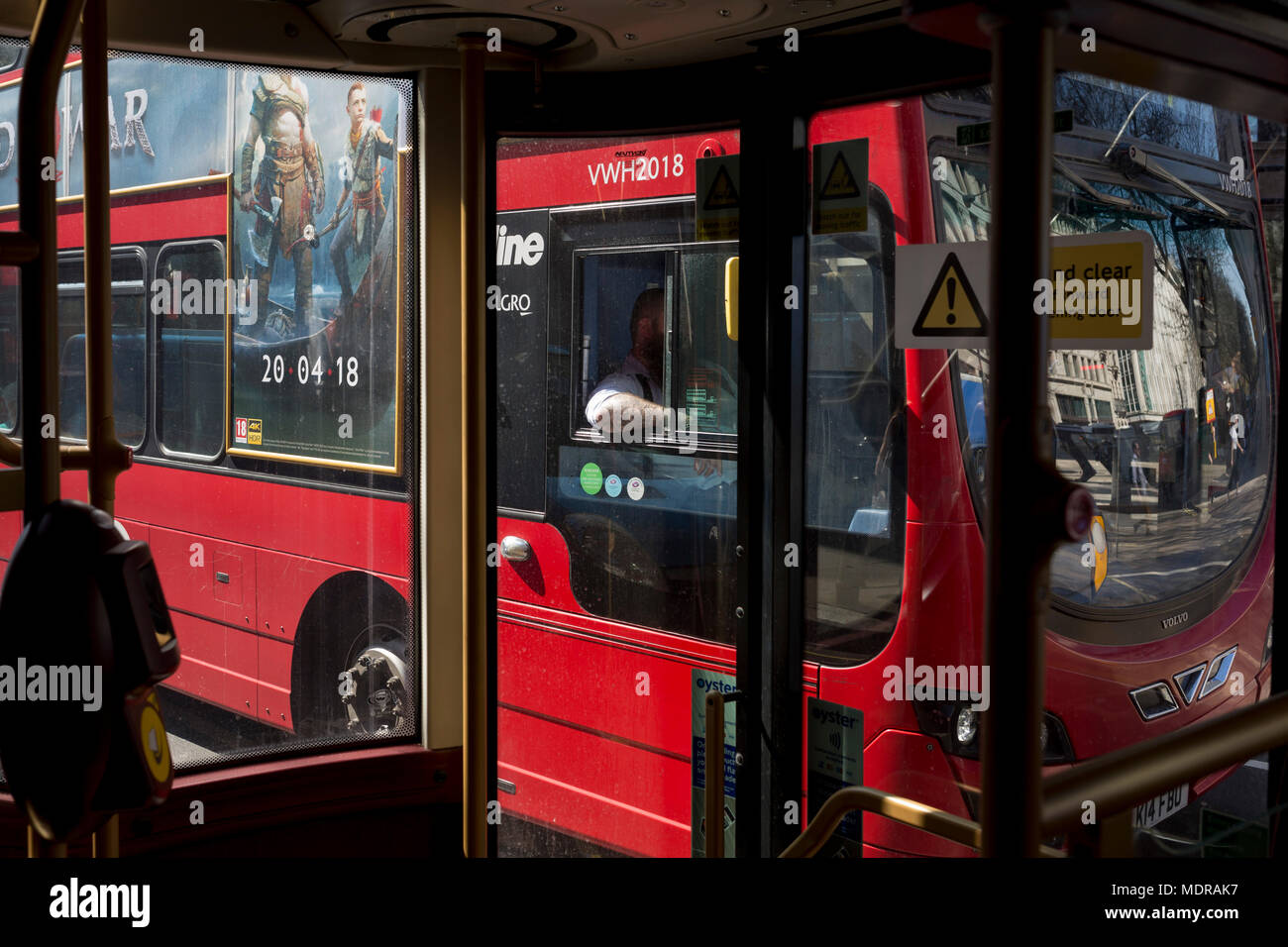 Die tätowierte Arm von einem Busfahrer und eine Anzeige für eine neue Playstation Spiel "der Gott des Krieges, am 19. April 2018 in London, England. Stockfoto