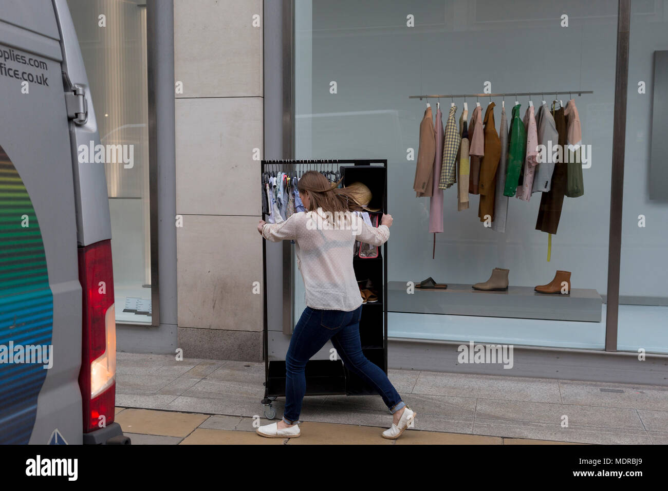 Ein Mitarbeiter vom Einzelhändler Zara, schiebt ein Rack mit Kleidung Kinder  auf New Bond Street, am 16. April 2018 in London, England Stockfotografie -  Alamy