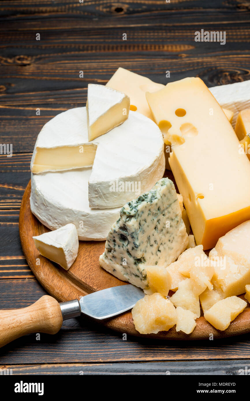 Verschiedene Arten von Käse-Brie, Camembert, Roquefort und Cheddar auf Holzbrett Stockfoto