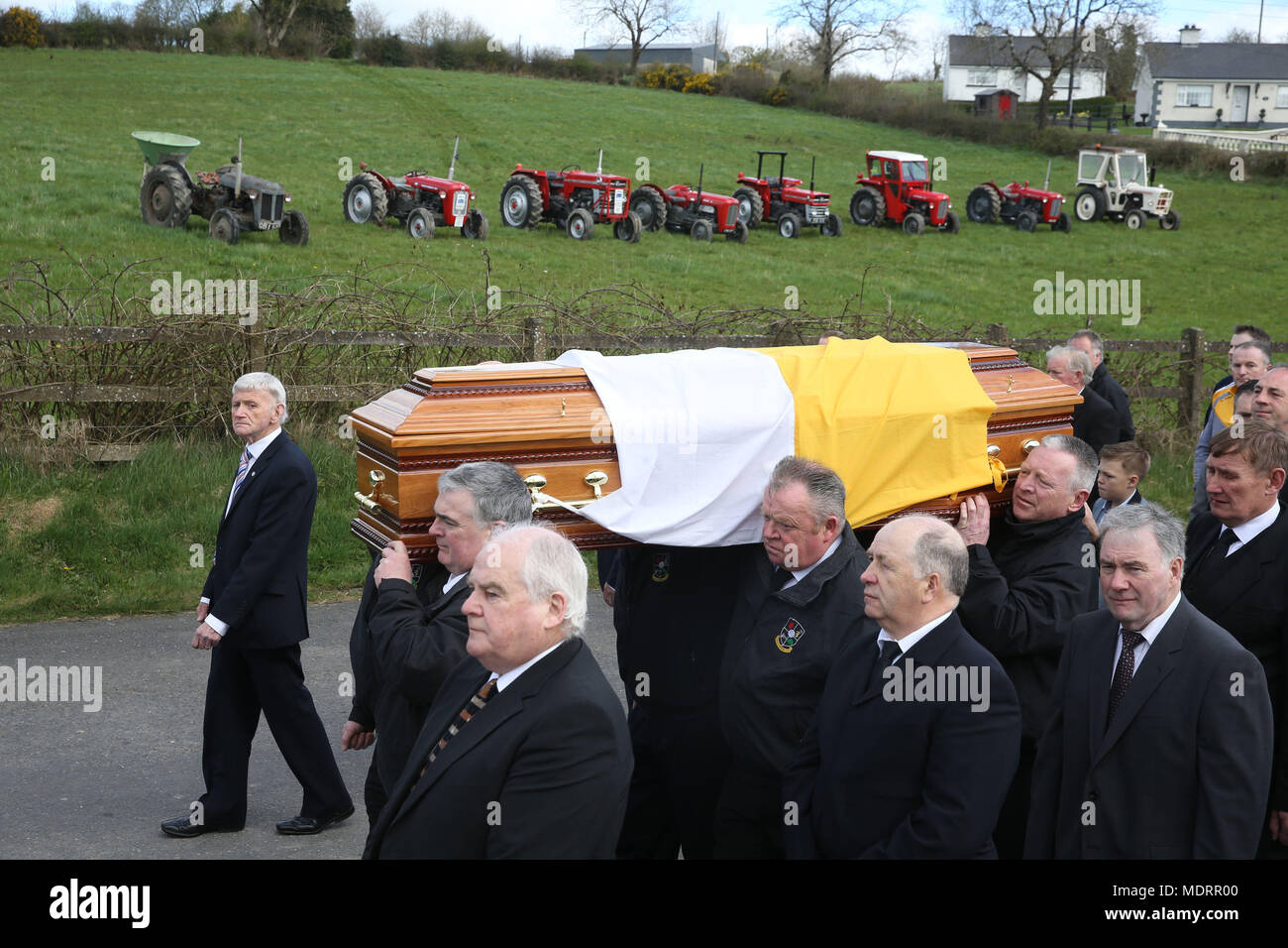 Die trauerzuges macht es Weg nach Saint Patrick's Kirche in Oram, County Monaghan, für die Beerdigung der Country Music Star Big Tom McBride, pass eine Linie von Oldtimer Traktoren, von denen einige der Sänger gehörte. Stockfoto