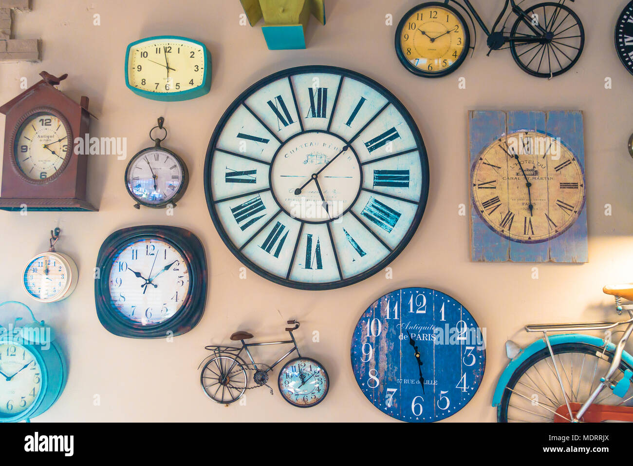 Eine Sammlung von Uhren und Modell Fahrräder schmücken eine Wand. Stockfoto