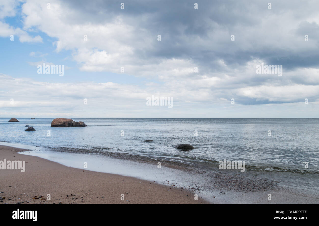 Eine leere ruhigen Strand mit einigen großen Steinen in ruhigem Meer auf der estnischen Insel Prangli. Stockfoto