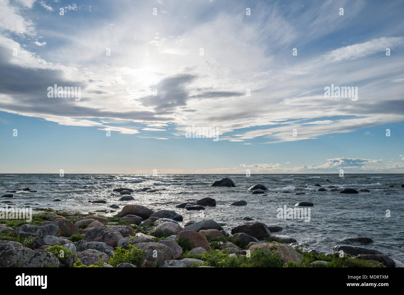 Ein steiniger Strand und flachen Gewässern der westlichen Küste von estnischen Prangli Insel mit schönen cirrus Wolken über. Stockfoto