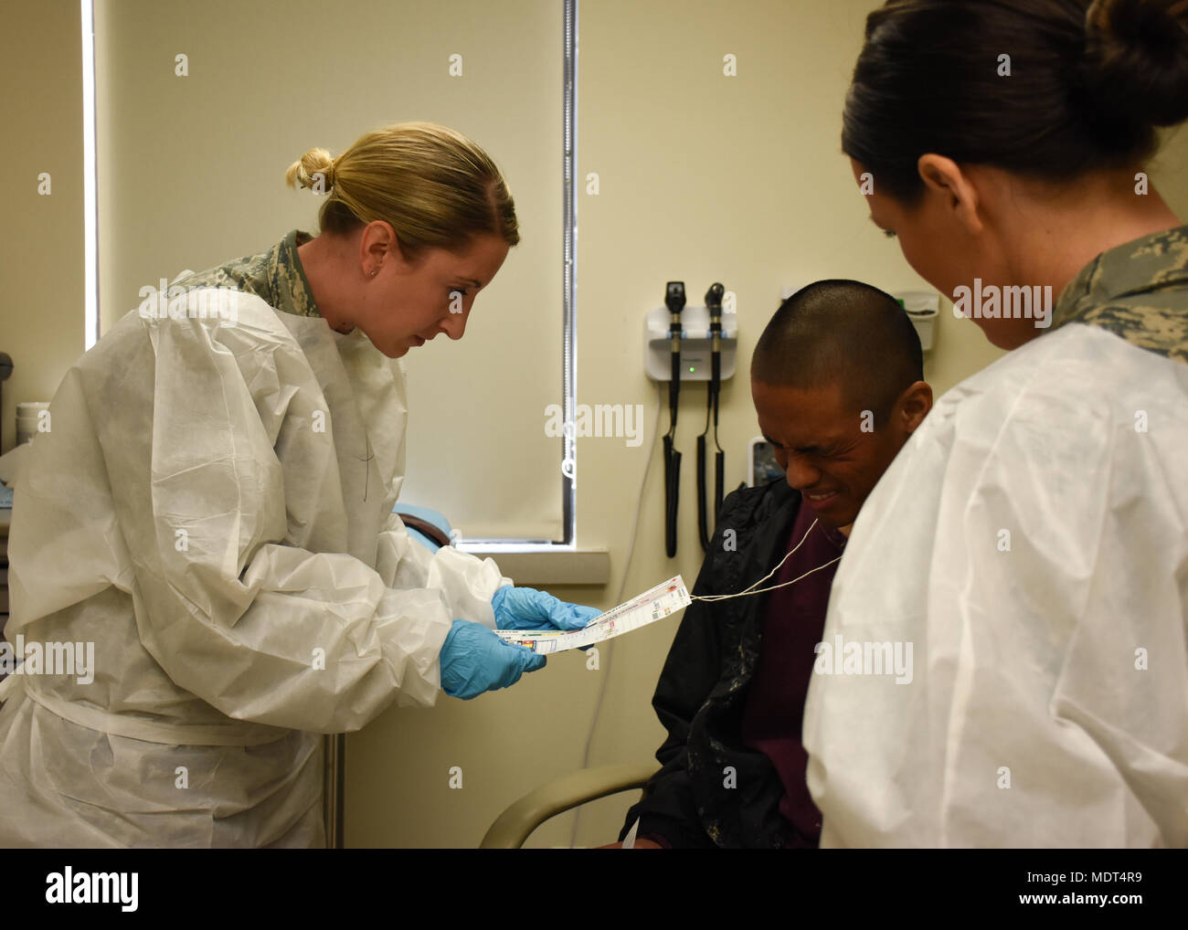 Us Air Force medizinisches Personal aus Team Whiteman ein Patient simulieren grippeartige Symptome und Exposition für Chlorgas, das bei einer totalen Kraft, Masse und Unfallversicherung und der Verteilung übung Dez. 2, 2017, an Whiteman Air Force Base, Calif. Medizinisches Personal ihre Fähigkeit, universelle Vorsichtsmaßnahmen zu verwenden und richtig behandeln Patienten nachgewiesen. (U.S. Air Force Foto von älteren Flieger Missy Sterling) Stockfoto