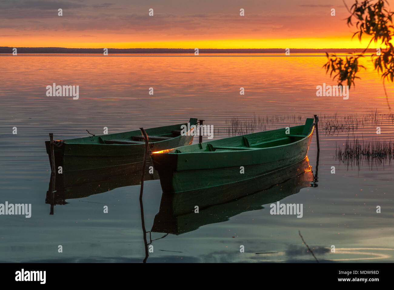 Zwei Boote aus Holz vor dem Hintergrund der hellen Sonnenuntergang Farben Stockfoto