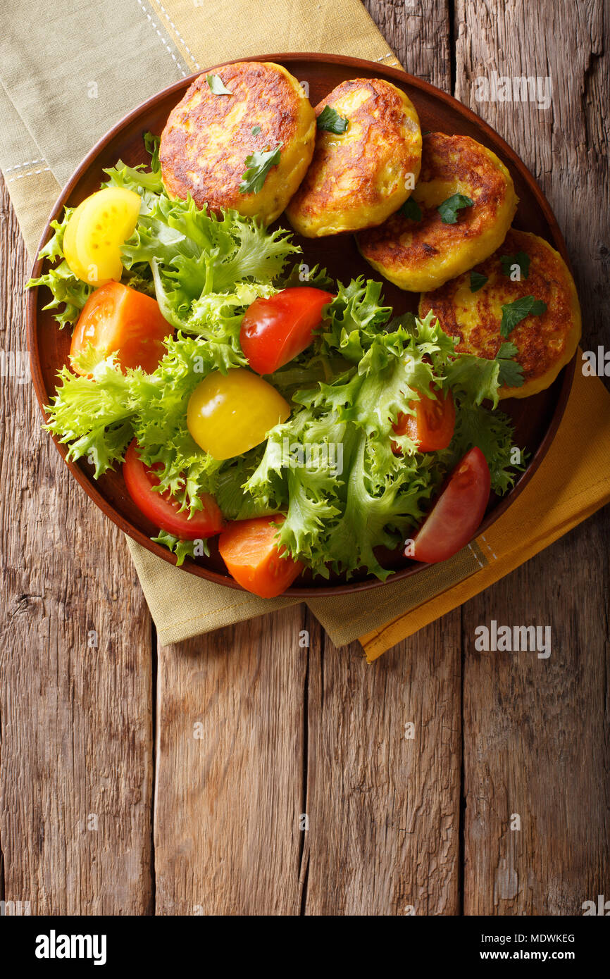 Frisch zubereitet Kartoffelpuffer mit frischem Salat in der Nähe serviert auf einem Teller. Vertikal oben Ansicht von oben Stockfoto