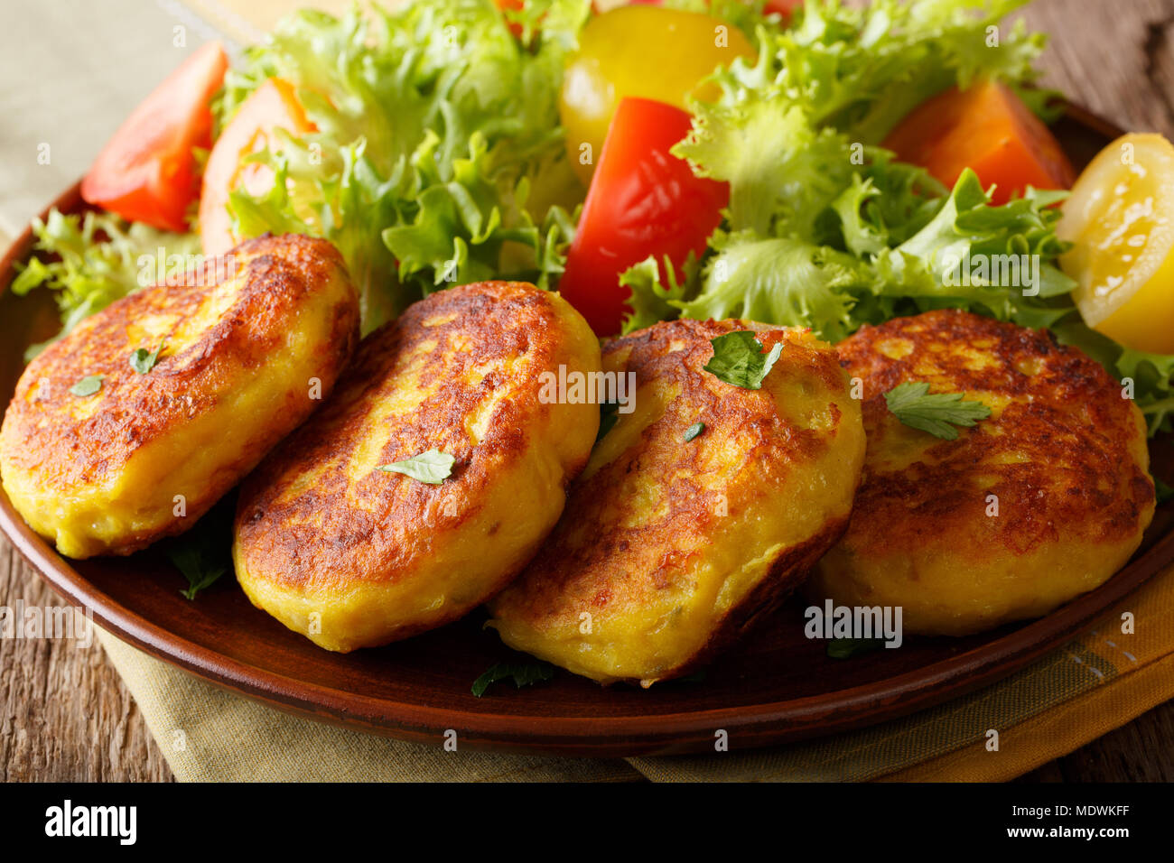 Frisch zubereitet Kartoffelpuffer mit frischem Salat in der Nähe serviert auf einem Teller. Horizontale Stockfoto