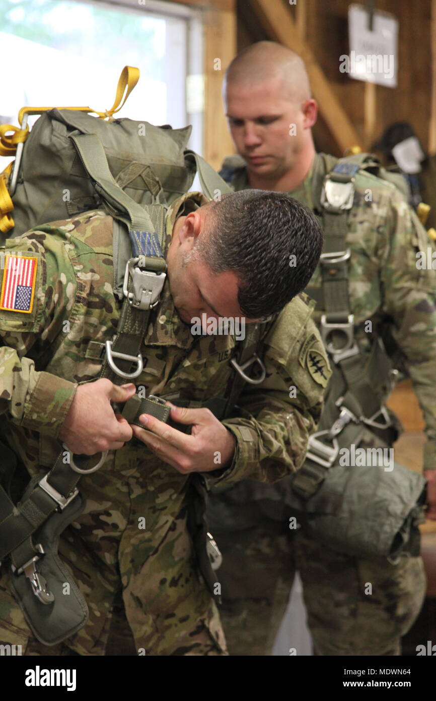 Us-Armee Fallschirmjäger don ihre fallschirme vor dem Jumpmaster persönliche Inspektion (JMPI) während der 20. jährlichen Randy Oler Memorial Betrieb Spielzeug Fallen, bewirtet durch die US-Armee die zivilen Angelegenheiten & psychologische Operations Command (Airborne), Dez. 6, 2017 MacKall Army Airfield, North Carolina. Betrieb Spielzeug Drop ist der weltweit größte kombinierten Betrieb mit neun Partner nation Fallschirmjäger teilnehmenden und Soldaten erlaubt, die Möglichkeit, auf ihren militärischen beruflichen Spezialgebiet zu trainieren, pflegen ihre Bereitschaft, in die Luft und wieder zurück in die lokale Gemeinschaft zu geben. (U.S. Armee Foto von Sgt John Jo Stockfoto