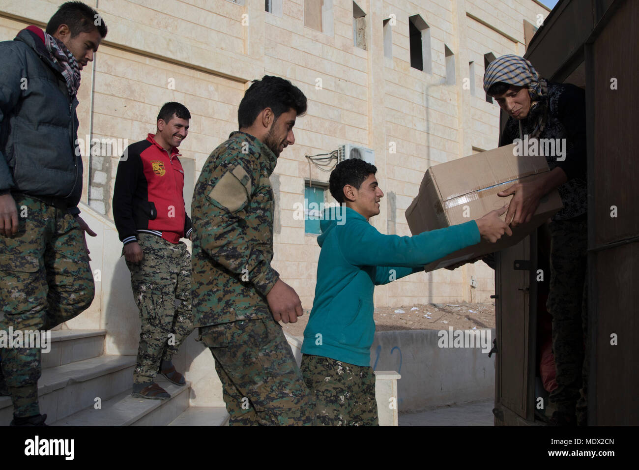 Ein Lkw mit der medizinischen Versorgung aus der zivilen Krankenhaus in al-Hasaka Stadt wird von mehreren Syrischen demokratischen Kräfte Soldaten, die Arbeit an der Medizinischen Klinik in Shaddadi, Syrien, 10.12.2017, live und ohne Last. Dieser medizinischen Versorgung wurden der SDF angesichts der lokalen medizinischen Klinik und frontline Ambulanzen in Shaddadi zu unterstützen. Die Shaddadi Krankenhaus, das derzeit von der SDF als medizinische Klinik in einem Teil des Gebäudes, war der größte National Hospital in hasaka Governate vor Daesh Terroristen die Kontrolle über die Gebäude. Das Ziel für die SDF ist das Gebäude übergang zurück zu einem c Stockfoto