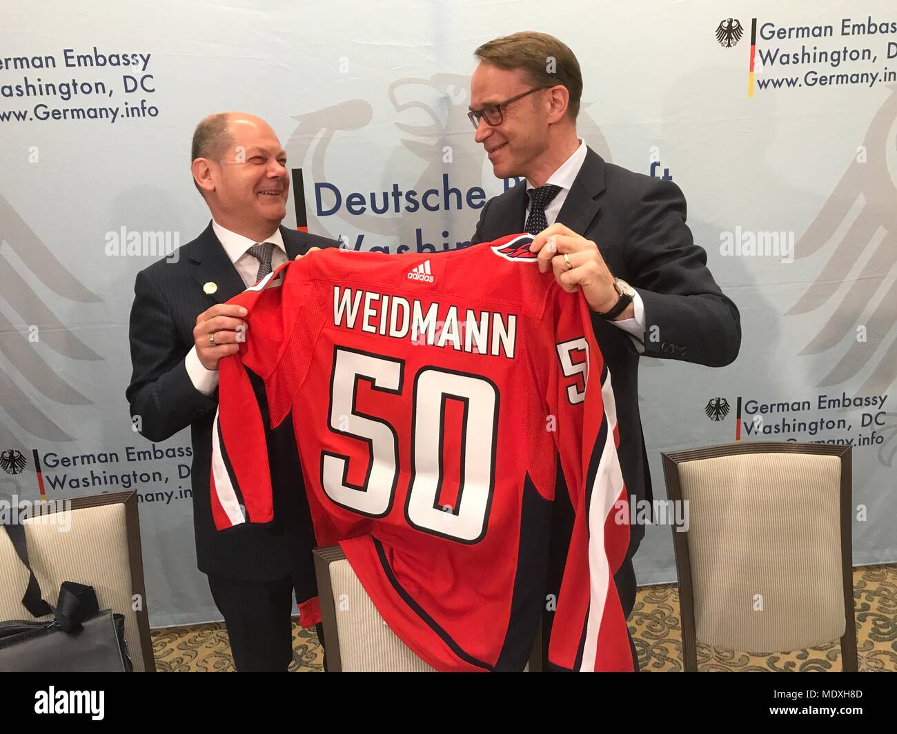 20. April 2018, in den USA, Washington: der deutsche Finanzminister Olaf Scholz (l) von der Sozialdemokratischen Partei (SPD) Hände Jens Weidmann, Präsident der Deutschen Bundesbank, ein Eis Hockey Jersey als Geschenk für seinen 50. Geburtstag. Foto: Georg Ismar/dpa Quelle: dpa Picture alliance/Alamy leben Nachrichten Stockfoto