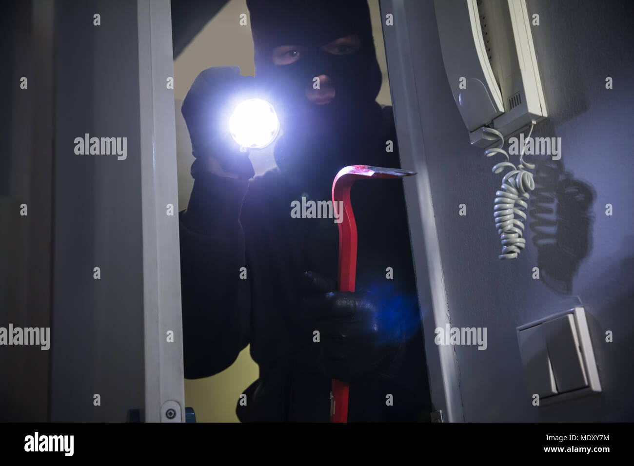 Dieb mit Taschenlampe und Brecheisen Eingabe in das Haus Stockfoto