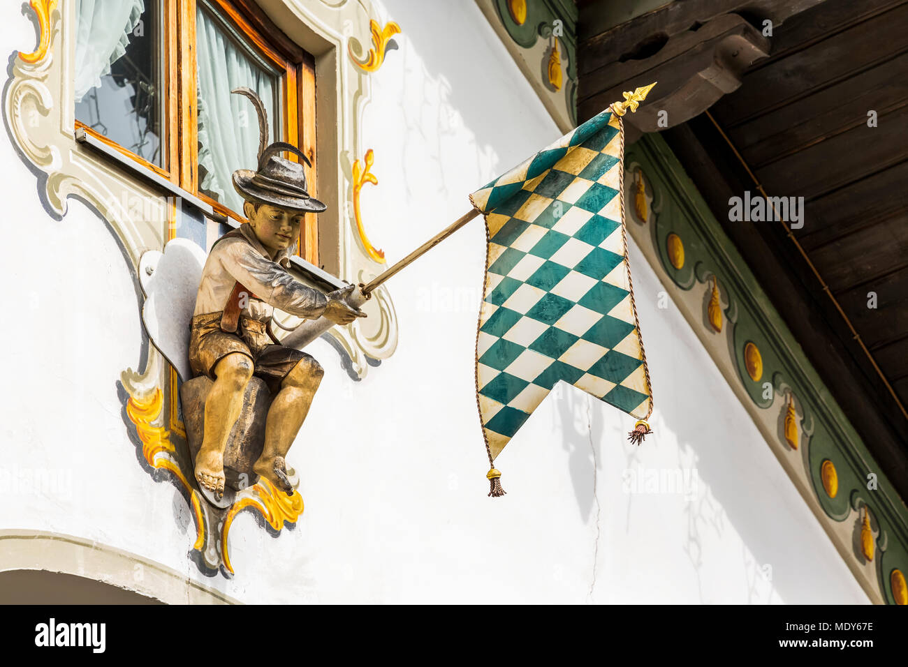 Close-up Dekorative sculputure Holding eine Fahne auf Seite eines bemalten Fensterrahmen auf Gebäude; Grainau, Bayern, Deutschland Stockfoto