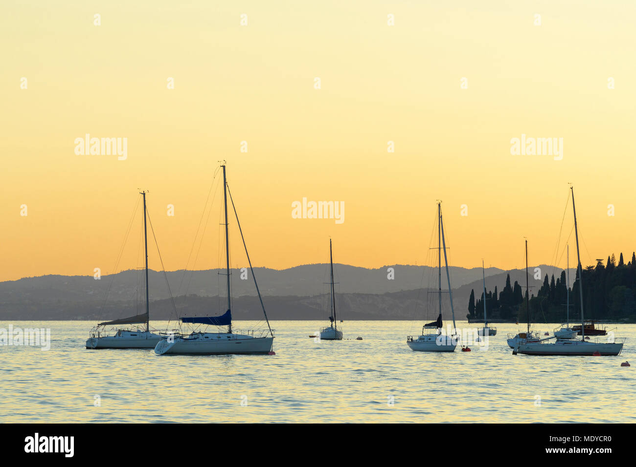 Segelboote am Gardasee (Lago di Garda) bei Sonnenuntergang in Gardasee in Venetien, Italien Stockfoto