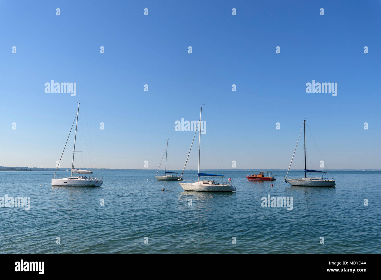 Segelboote verankert Am Gardasee (Lago di Garda) an einem sonnigen Tag in Gardasee in Venetien, Italien Stockfoto