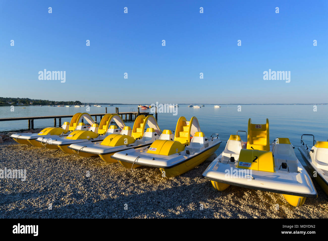 Reihe von farbenfrohen Tretboote am Strand am Morgen am Gardasee (Lago di Garda) in Bardolino, in Venetien, Italien Stockfoto