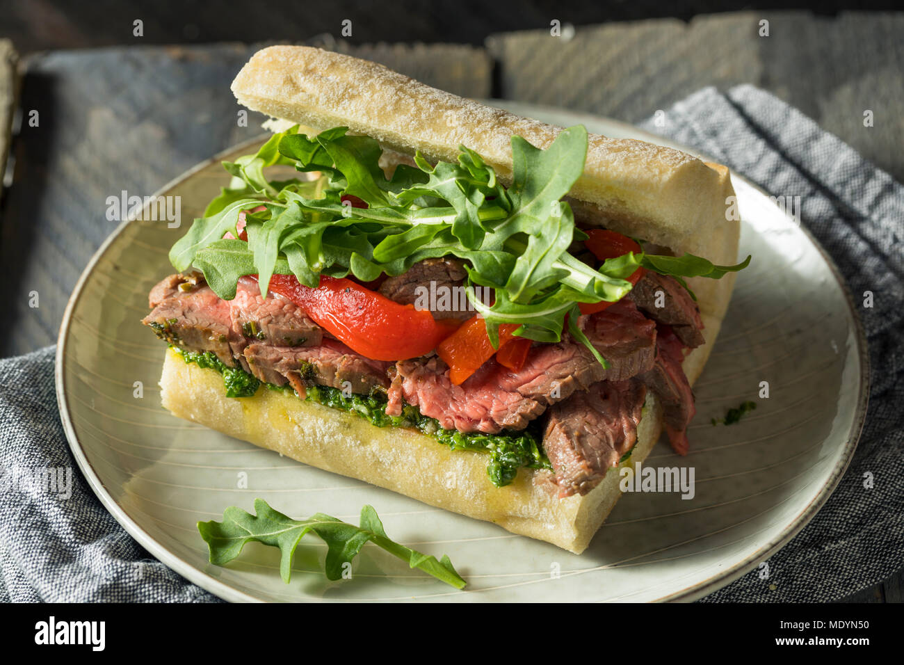 Hausgemachtes Rindfleisch Steak Sandwich mit Chimichurri und Rucola Stockfoto