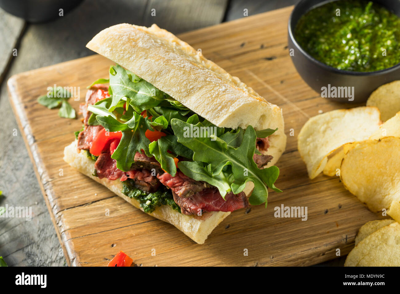 Hausgemachtes Rindfleisch Steak Sandwich mit Chimichurri und Rucola Stockfoto
