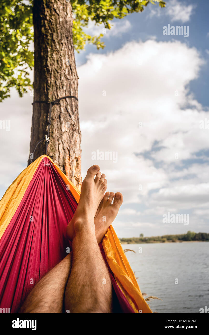 Relaxen in der Hngematte am Strand unter einem Baum, Sommer Tag. Barfu  Mann in der Hngematte, auf der Suche nach einem See, inspirierende  Landschaft Stockfotografie - Alamy