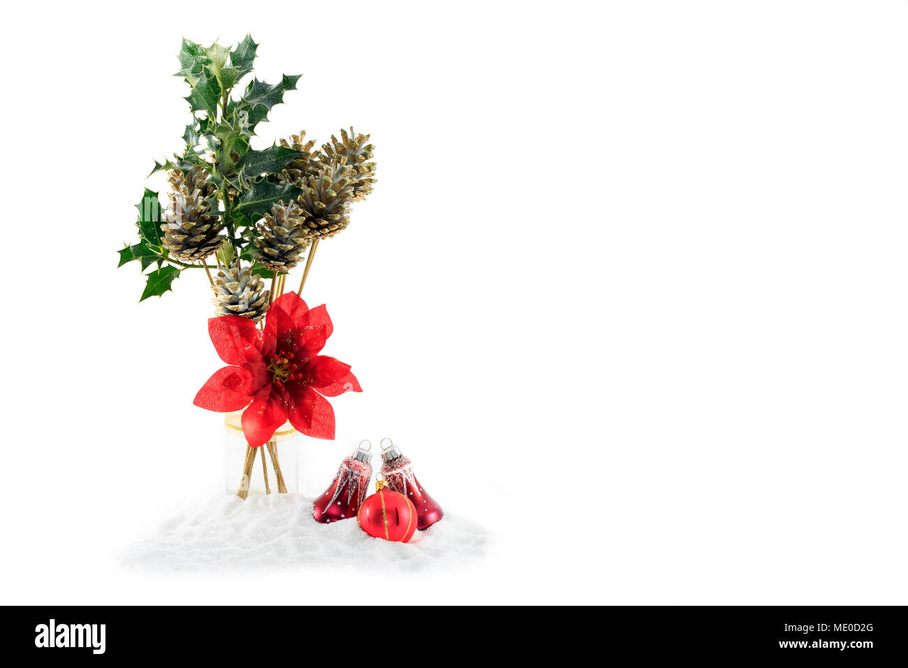 Weihnachtsdekoration von gold lackierte Tannenzapfen, grün Holly, in Glas Glas auf Kunstschnee, Weihnachtsstern Blume isoliert auf weißem Stockfoto