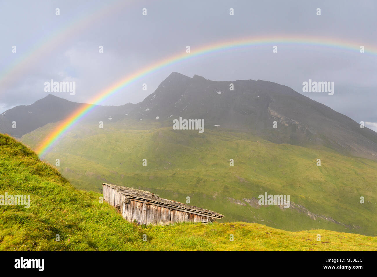 Regenbogen über Berglandschaft mit Hütte bei Kaiser Franz Josefs Hohe im Nationalpark Hohe Tauern in Kärnten, Österreich Stockfoto