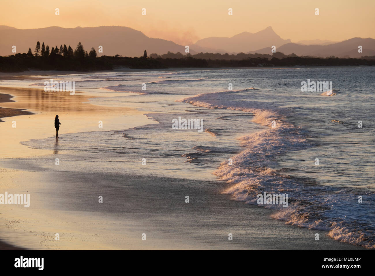 Silhouette der Person am Strand beobachten die Wellen schlagen das Ufer bei Byron Bay in New South Wales, Australien Stockfoto