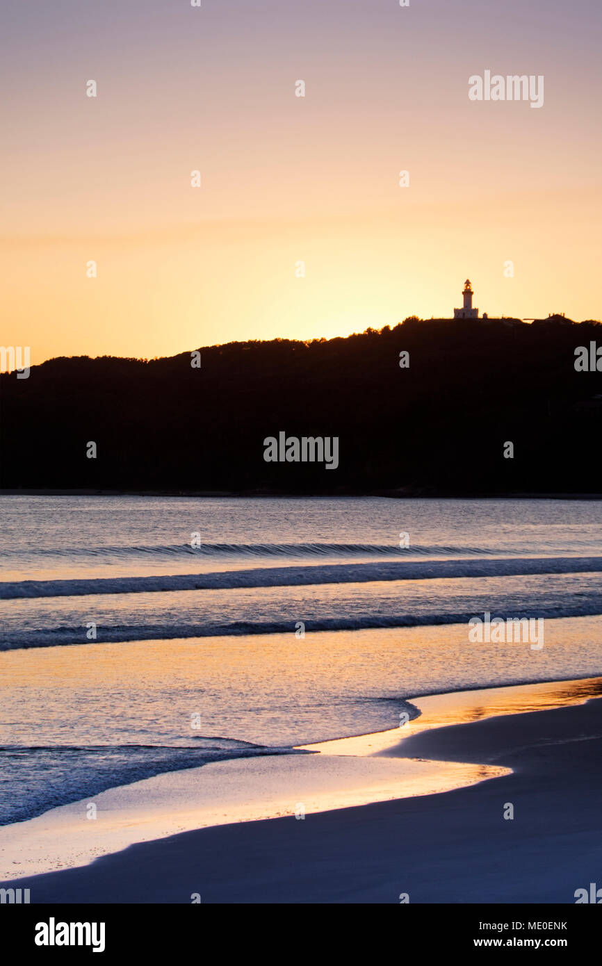 Silhouette von Cape Byron Lighthouse und sonnigen Strand bei Sonnenuntergang bei Byron Bay in New South Wales, Australien Stockfoto