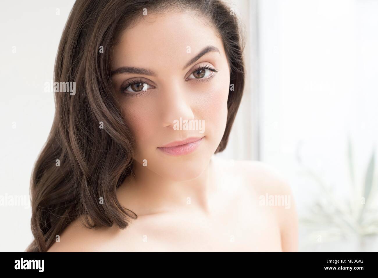 Junge Frau mit braunen Haaren an Kamera suchen, Portrait. Stockfoto