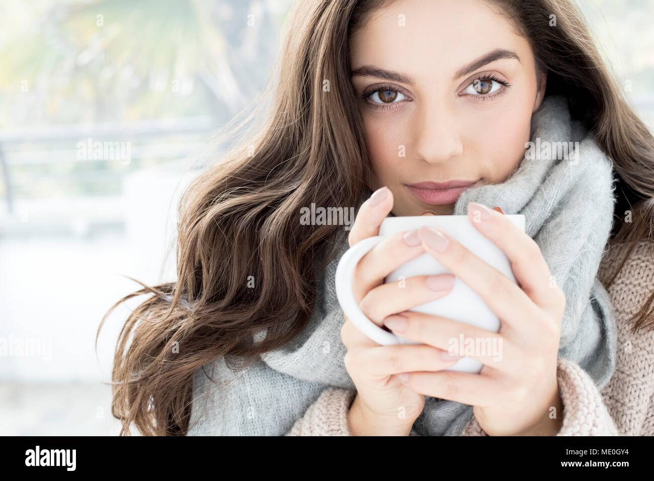 Junge Frau mit grauen Schal holding Tasse. Stockfoto