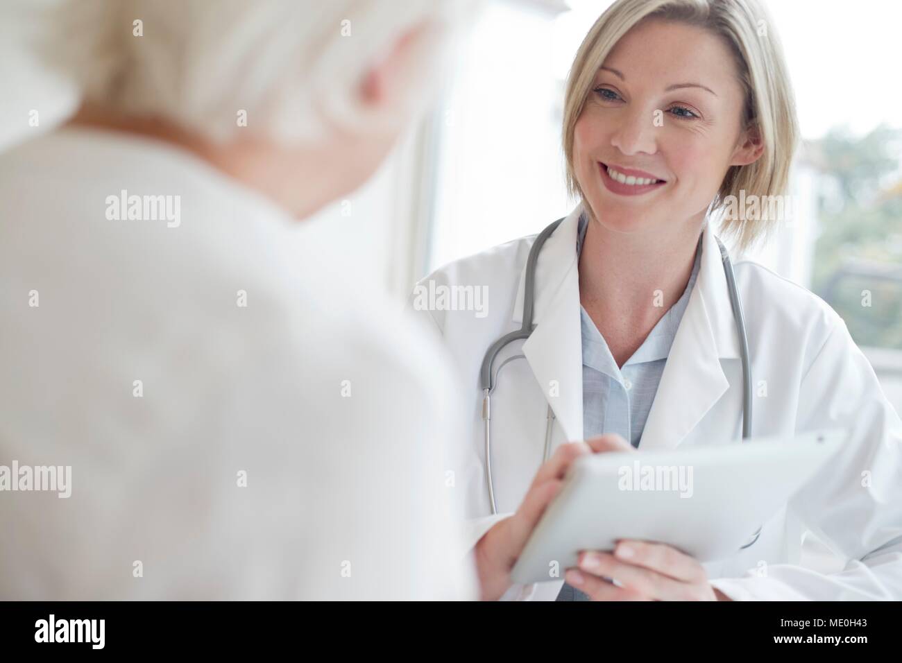 Ärztin mit digitalen Tablet mit Patienten. Stockfoto