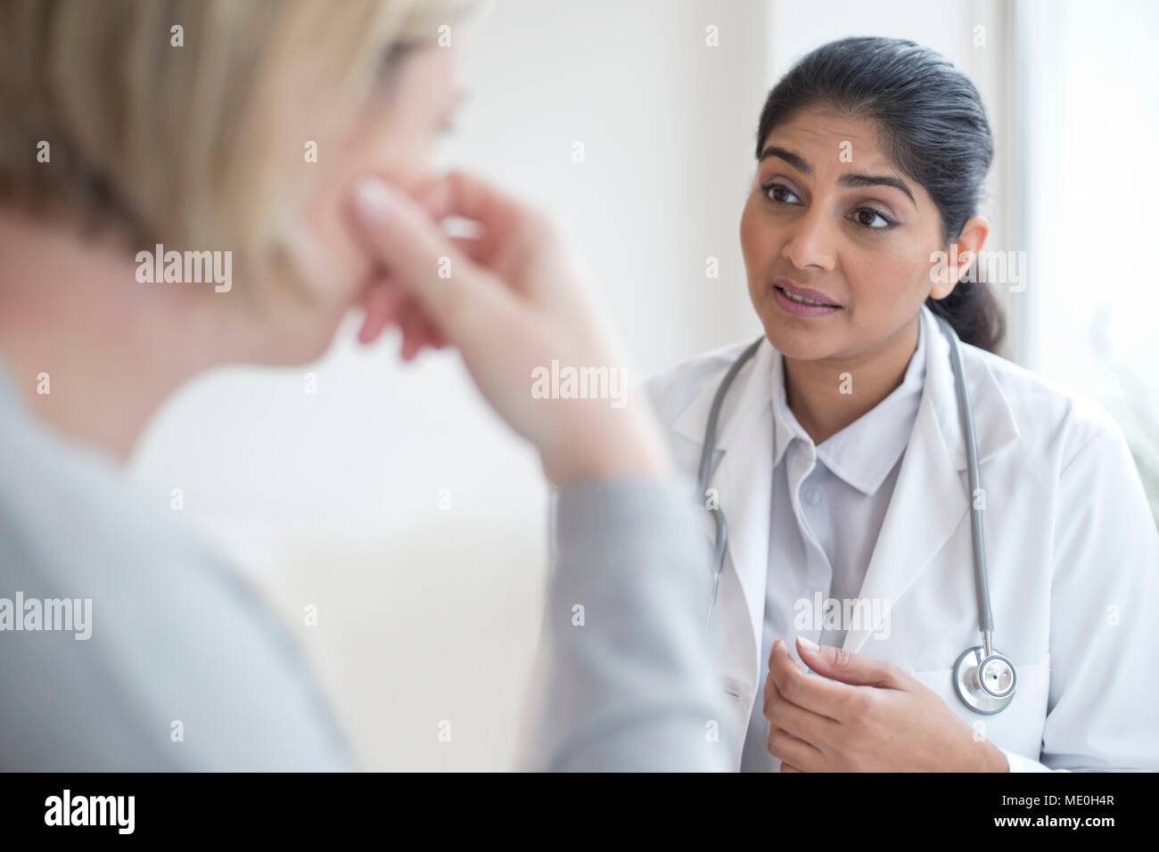 Ärztin im Gespräch mit Patienten. Stockfoto