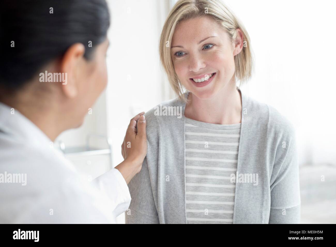 Frau Doktor mit Hand auf die Schulter des Patienten. Stockfoto