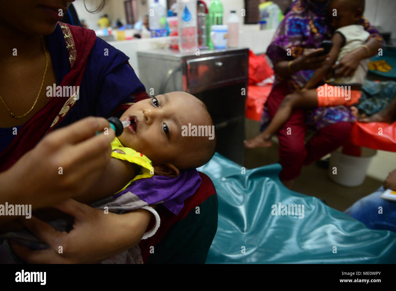 Bangladesch eine Mutter ihre Kinder füttern Kochsalzlösung, leidet an Durchfall liegen im Internationalen Zentrum für Durchfall Erkrankung Forschung, Banglad Stockfoto