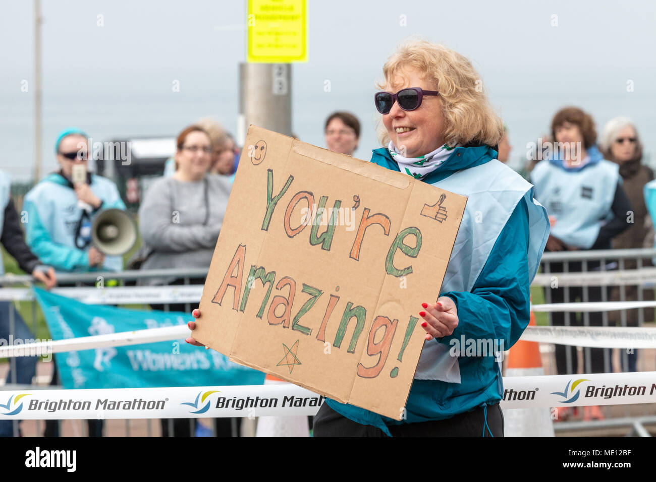 Brighton, Sussex, UK, 15. April 2018; Freiwillige ermutigt Läufer in den Brighton 10K Rennen mit einem inspirierenden Botschaft auf ein selbstgemachtes Schild Stockfoto