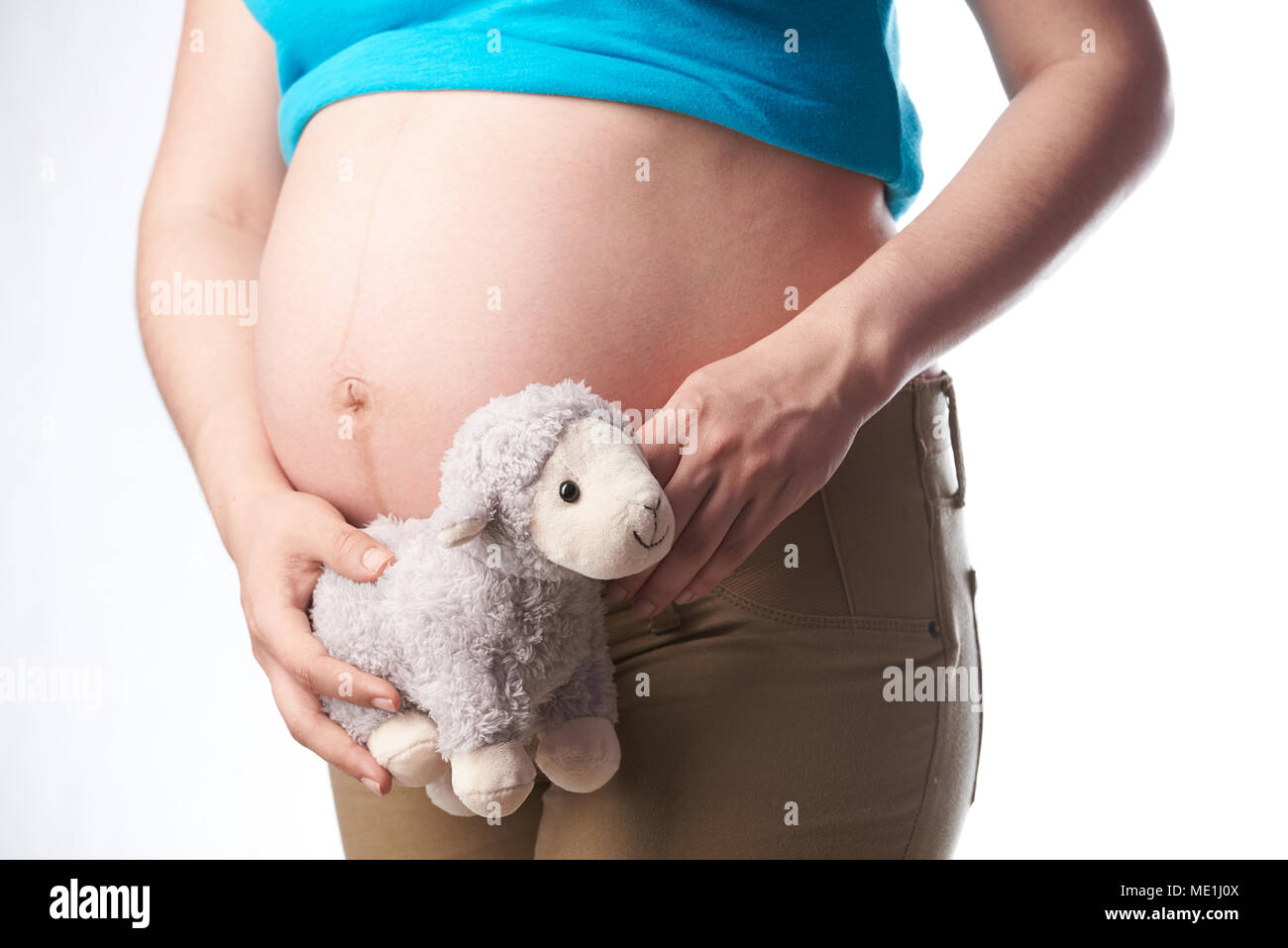 Pregnat Frau Bauch holding Spielzeug schließen bis auf weißem Hintergrund Stockfoto