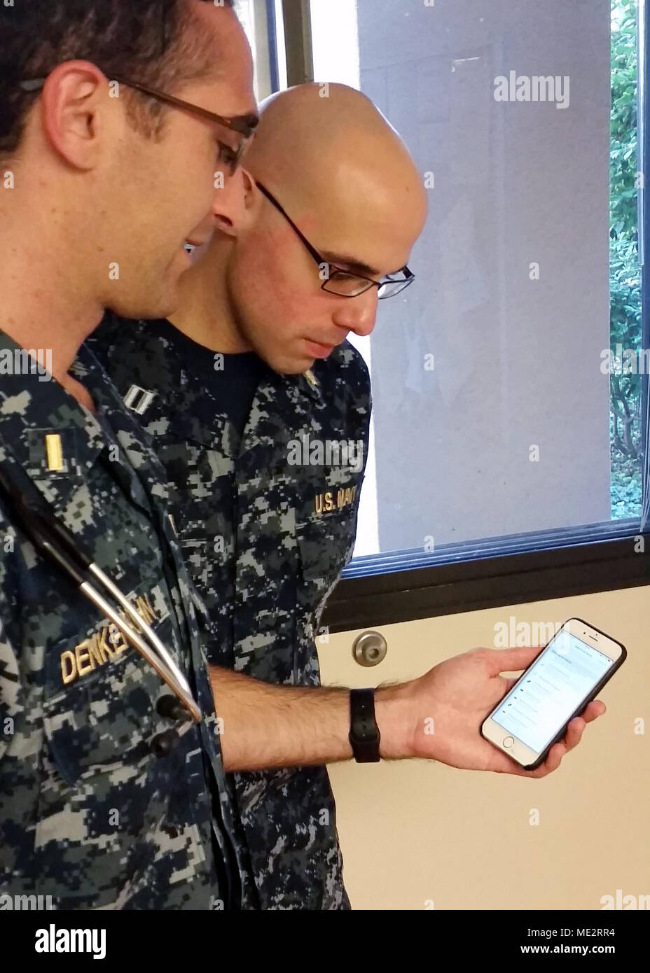 Uniformed Services University of the Health Sciences ist eine US-amerikanische Bundesuniversität für Gesundheitsberufe in Bethesda, Maryland, die Militärärzte und medizinische Fachkräfte ausbildet. Das Archivbild dokumentiert einen Navy Fähnrich und Medizinstudenten, der die µBio Referenz iPhone Anwendung mit einem Navy internistischen Arzt im Naval Medical Center San Diego diskutiert. Stockfoto