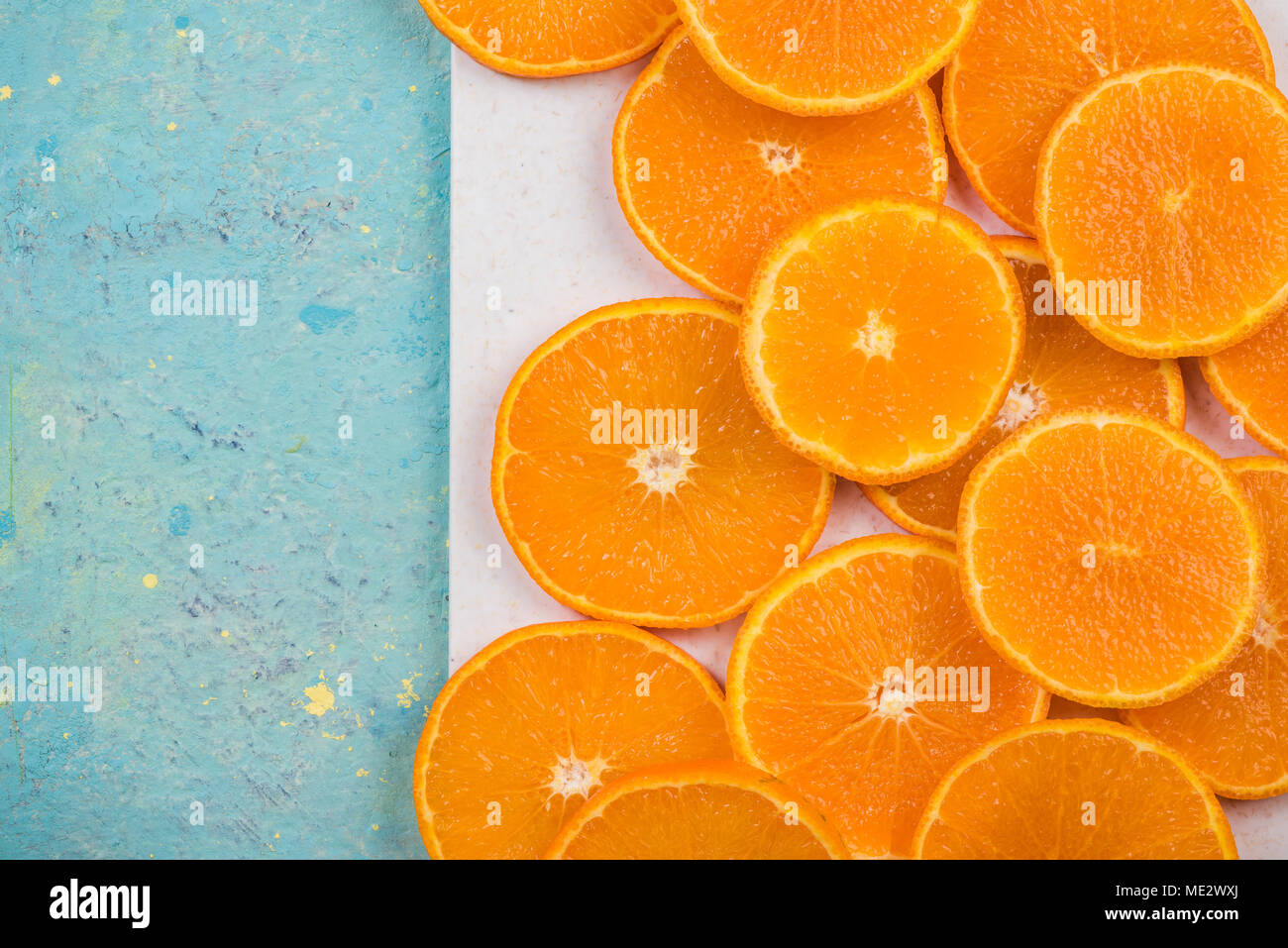 Orangenscheiben auf Marmor und blauen Tabelle. Lebendige Nahrung Bild. Stockfoto