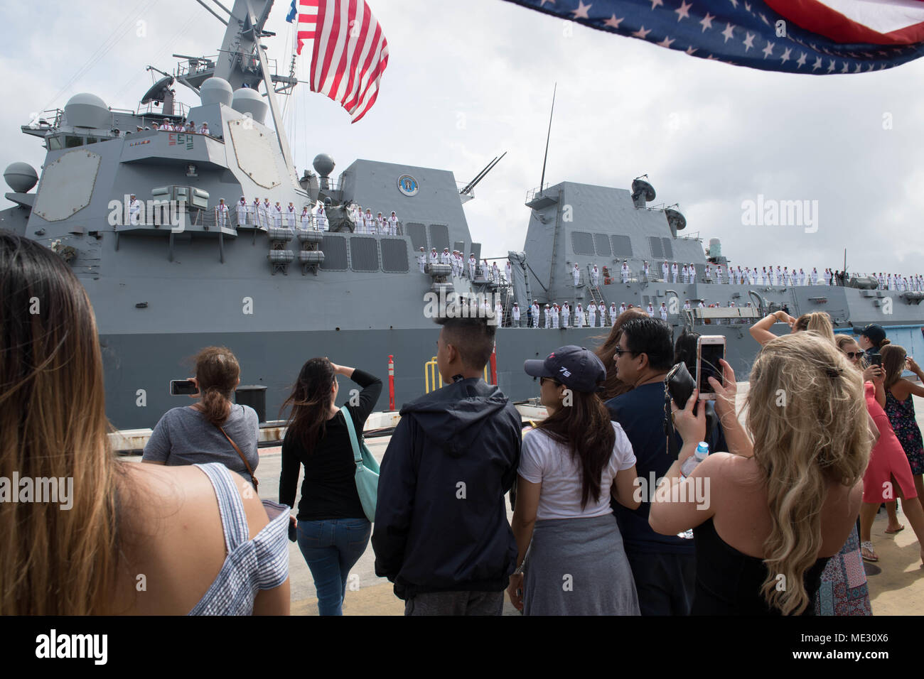 180418-N-ND 356-0044 Pearl Harbor (18. April 2018) militärische Mitglieder, Familie und Freunde warten auf die arleigh Burke-Class geführte Anti-raketen-Zerstörer USS Michael Murphy (DDG112) Zurück zu Pearl Harbor nach einem dreimonatigen Einsatz für den westlichen Pazifik mit dem Carl Vinson Streik Gruppe. Die Crew von 350 Segler durchgeführten Schulungen mit der Französischen Marine und besucht die Philippinen und Guam. USS Michael Murphy führte auch einen gemeinsamen Ozeanien Maritime Security Initiative (OMSI) Patrouille mit der US-Küstenwache. (U.S. Marine Foto von Mass Communication Specialist 3. Klasse Jessica O. Blackwell) Stockfoto