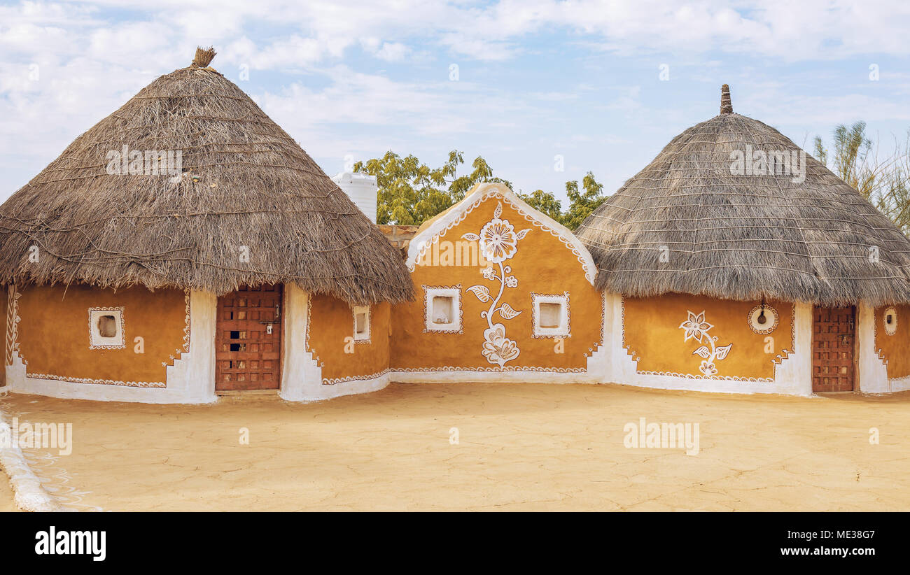 Dorf in der Nähe der Wüste Thar Rajasthan Jaisalmer Indien mit strohgedeckten Lehmhütten und gestrichenen Wänden. Stockfoto